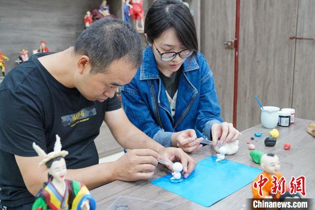<a target='_blank'  data-cke-saved- >中新社</a>記者(右)現場體驗面塑制作過程?！￡悹帍?攝