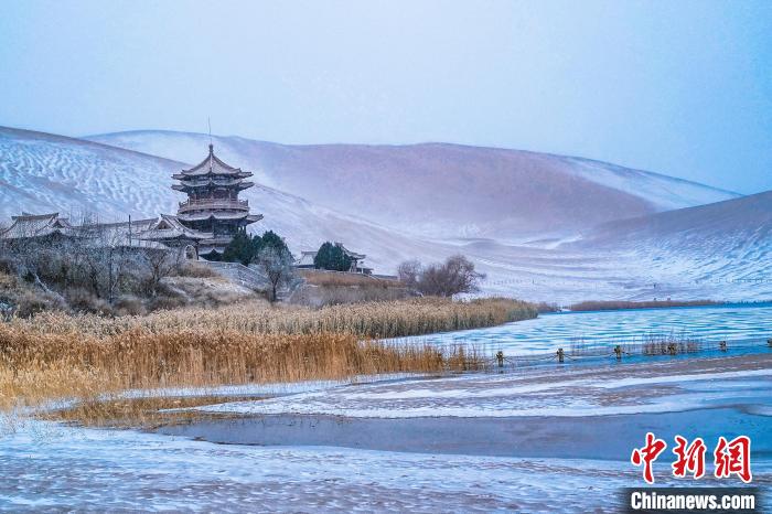 2021年11月28日，雪落鳴沙山月牙泉景區?！⊥醣筱y 攝