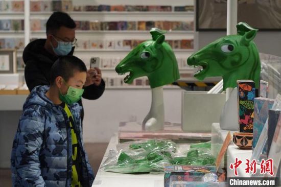 圖為“神馬來了”銅奔馬頭套吸引參觀者駐足。　九美旦增 攝