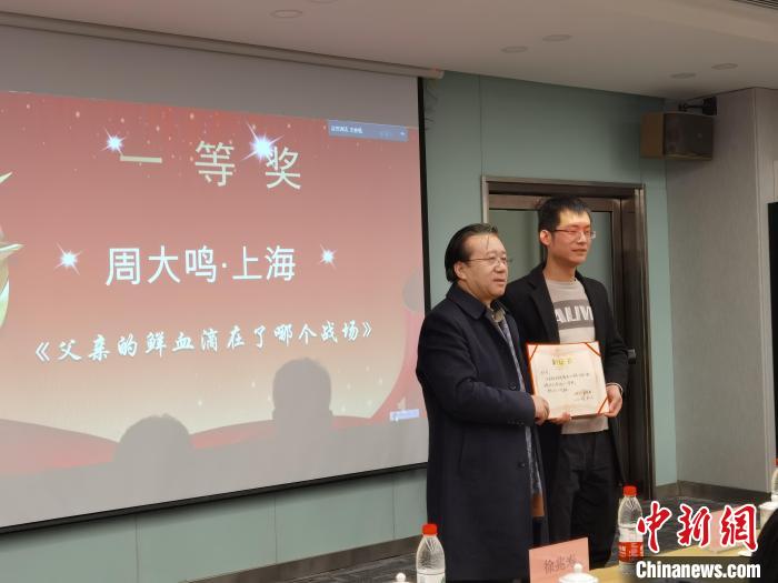 圖為作家、西北師范大學新聞與傳媒學院院長徐兆壽頒發一等獎證書,代領獎者上臺領獎。 楊娜 攝 圖為作家、西北師范大學新聞與傳媒學院院長徐兆壽頒發一等獎證書,代領獎者上臺領獎。 楊娜 攝