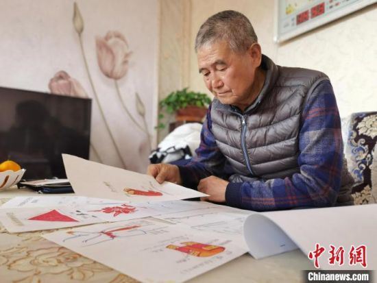 圖為陸鵬飛向記者展示多年帶隊(duì)的手寫筆記。　張婧 攝