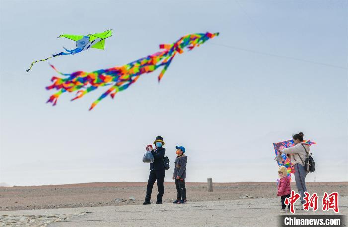 圖為孩童在父母的陪伴下放風(fēng)箏?！⊥醣筱y 攝