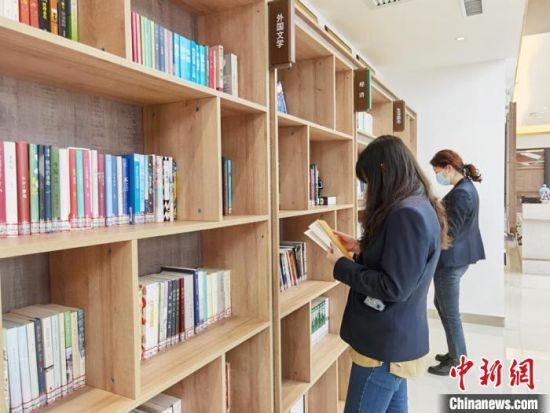 圖為在甘肅公航旅建設集團有限公司的職工書屋，職工挑選書籍?！⌒煅?攝