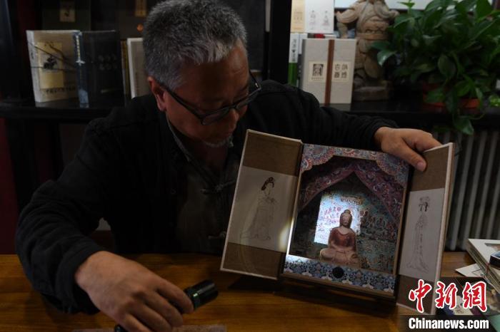圖為讀者出版集團(tuán)讀者晉林工作室獨(dú)立出品人徐晉林，展示互動性強(qiáng)的敦煌題材手工書。(資料圖) 楊艷敏 攝