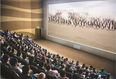 游客在莫高窟數(shù)字展示中心觀看主題電影《千年莫高》。 游客在莫高窟數(shù)字展示中心觀看主題電影《千年莫高》。