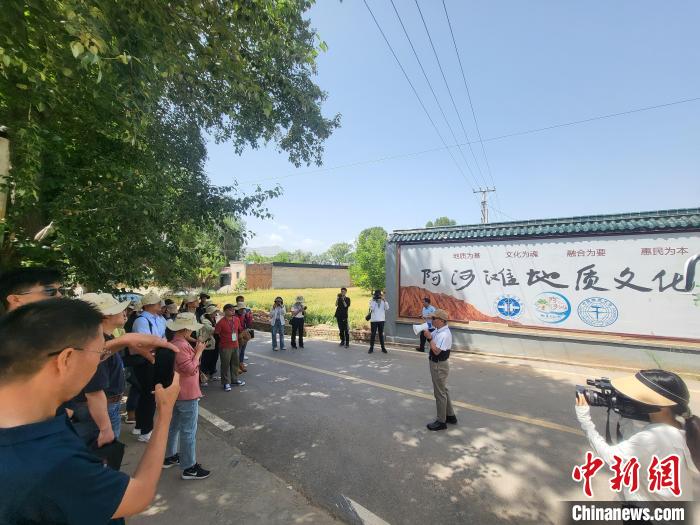 圖為中國地質大學(北京)教授張緒教介紹村落情況。　胡友軍 攝