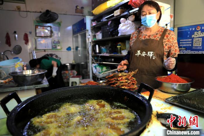 圖為平安驛·河湟民俗文化體驗地內的商戶炸干板魚。　薛蒂 攝