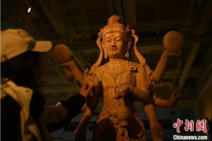 圖為季茂杰觀察自己創作的敦煌木雕。李亞龍 攝</p>
<p>