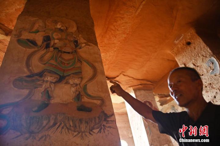 7月15日，甘肅省平?jīng)鍪袥艽h百里石窟長(zhǎng)廊羅漢洞石窟內(nèi)，該窟文保員郭建平介紹窟內(nèi)石刻彩繪壁畫。郭建平家中三代人曾自發(fā)保護(hù)羅漢洞石窟。羅漢洞石窟遺存40余個(gè)窟龕，以北魏至清代風(fēng)格為主。中新社記者 李亞龍 攝</p>
<p>