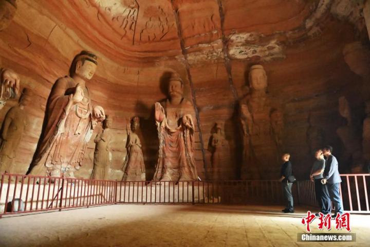 7月15日，游人參觀甘肅省平?jīng)鍪袥艽h百里石窟長(zhǎng)廊中的南石窟寺1號(hào)窟。百里石窟長(zhǎng)廊位于涇川縣境內(nèi)，由512個(gè)石窟、5眼窟中石井組成，現(xiàn)存王母宮石窟、鳳凰山石窟、南石窟寺、丈八寺石窟、羅漢洞石窟、太山寺石窟等規(guī)模較大的石窟群，還有數(shù)量眾多的小石窟群。南石窟寺開鑿于北魏永平三年，其中1號(hào)窟屬于大型七佛窟，七佛高達(dá)6米。中新社記者 李亞龍 攝