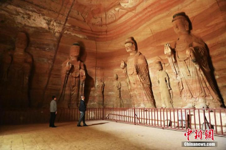 7月15日，游人參觀甘肅省平?jīng)鍪袥艽h百里石窟長(zhǎng)廊中的南石窟寺1號(hào)窟。百里石窟長(zhǎng)廊位于涇川縣境內(nèi)，由512個(gè)石窟、5眼窟中石井組成，現(xiàn)存王母宮石窟、鳳凰山石窟、南石窟寺、丈八寺石窟、羅漢洞石窟、太山寺石窟等規(guī)模較大的石窟群，還有數(shù)量眾多的小石窟群。南石窟寺開鑿于北魏永平三年，其中1號(hào)窟屬于大型七佛窟，七佛高達(dá)6米。中新社記者 李亞龍 攝