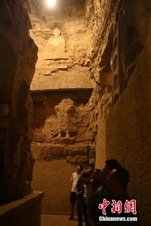 7月15日，游人參觀甘肅省平?jīng)鍪袥艽h百里石窟長(zhǎng)廊中的王母宮石窟。百里石窟長(zhǎng)廊位于涇川縣境內(nèi)，由512個(gè)石窟、5眼窟中石井組成，現(xiàn)存王母宮石窟、鳳凰山石窟、南石窟寺、丈八寺石窟、羅漢洞石窟、太山寺石窟等規(guī)模較大的石窟群，還有數(shù)量眾多的小石窟群。王母宮石窟又名千佛洞，該窟設(shè)計(jì)宏大，造像生動(dòng)，窟內(nèi)擁有造像數(shù)百尊，是較為珍貴的佛教文化遺存。中新社記者 李亞龍 攝</p>
<p>